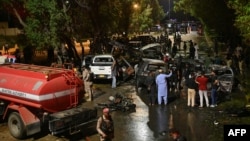 Security officials examine at the site of an explosion which occurred near Karachi airport late on October 6.