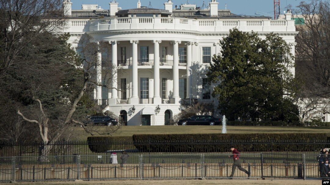 Greenpeace protesters unfold a banner reading "Resist" from atop a construction crane behind the White House January 25, 2017 in Washington, DC. The banner, flying high enough to be seen from the White House, is in opposition to the policies of President 
