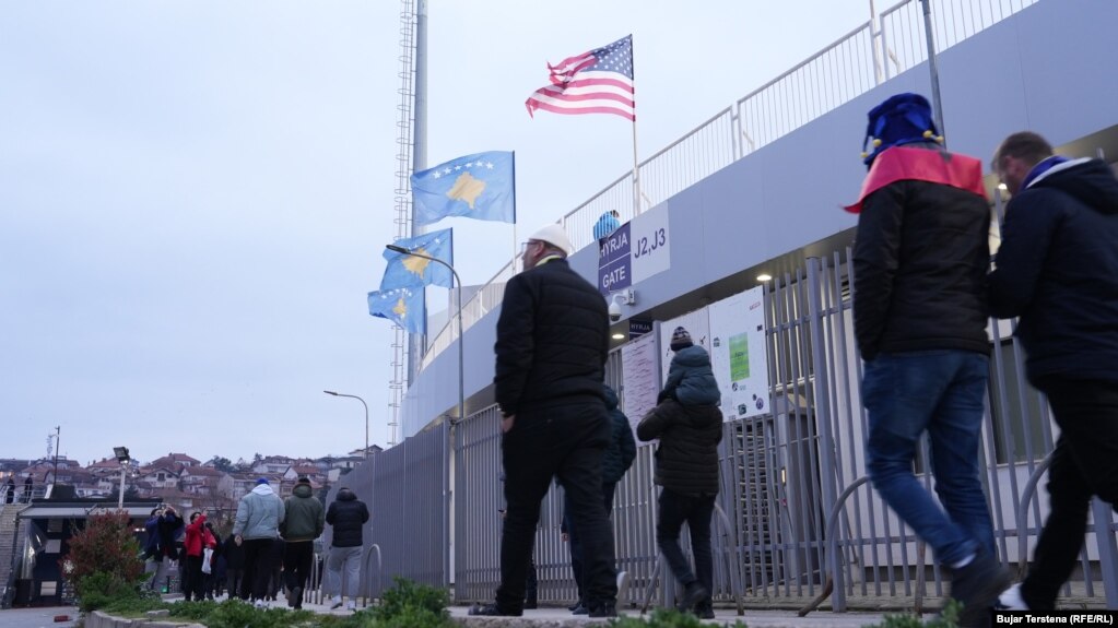 Flamuj të Kosovës dhe një flamur amerikan të vendosur në Stadiumin "Fadil Vokrri" teksa tifozët fillojnë të shkojnë në stadum për ndeshjen vendimtare të Kosovës kundër Turqisë për kualifikim në Botëror.