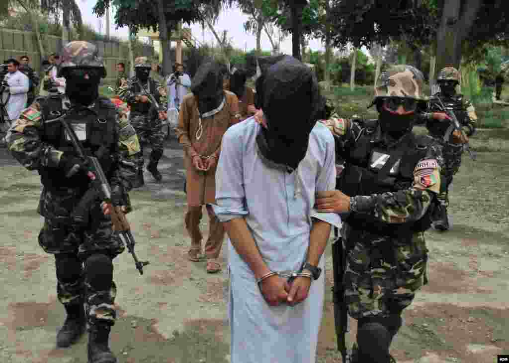 Members of the Afghan National Directorate of Security (NDS) escort four suspected Taliban members allegedly involved in criminal activities in the area after their arrest in Jalalabad. (epa/Ghulamullah Habibi)