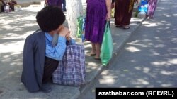 Ýoluň kenarynda oturan ýaşuly.