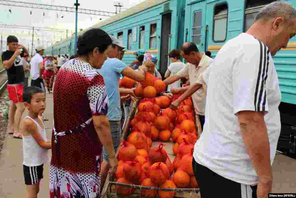 Пассажиры покупают дыни во время стоянки поезда.