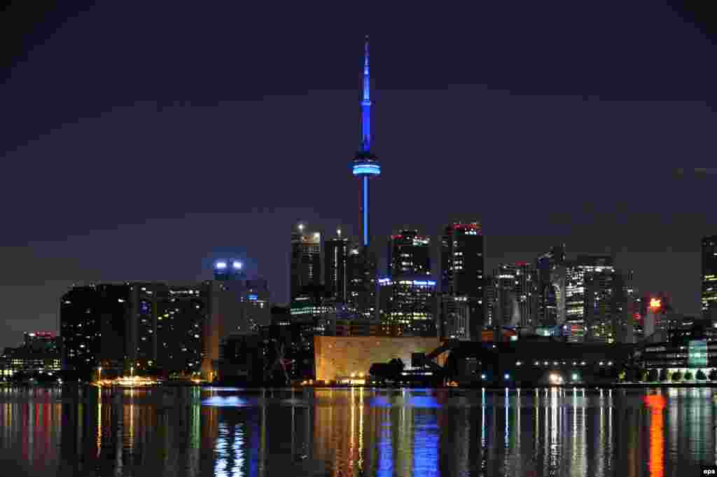 To celebrate the birth of British Prince William and his wife, Catherine, the CN Tower in Toronto is illuminated in blue light. The British monarch is officially the head of state of Canada.