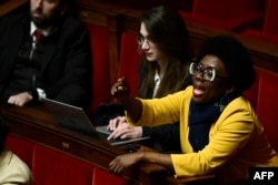 Deputata partidului de stânga La France Insoumise (LFI), Daniele Obono, reacționând într-o sesiune de întrebări și răspunsuri cu guvernul în Adunarea Națională, la 3 decembrie.