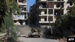 Syrian government forces take part in an operation to take control of Aleppo's Suleiman al-Halabi neighborhood, which is divided by the front line that separates the rebel-held east and regime-held west of the northern city, on September 30.