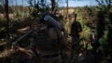 Український військовий несе снаряд до гаубиці на передовій на околицях Лимана, 15 серпня 2023 року