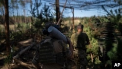 Український солдат несе снаряд до гаубиці на позиціях в околицях Лиману, Україна, 15 серпня 2023 року