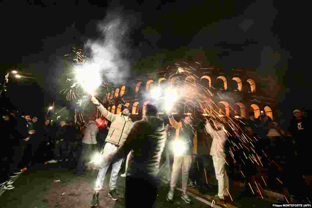 Nekoliko osoba slavi pored Koloseuma u Rimu uoči Nove godine, 31. decembra 2025.