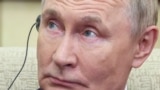 Russian President Vladimir Putin listens to a headphone translation in Beijing.