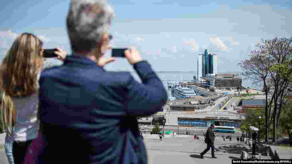 Туристи фотографують Потьомкінські сходи та морський вокзал