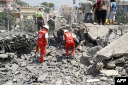 First aid responders and residents rush to the site of an Israeli airstrike that targeted a neighborhood in the southern Lebanese village of Deir al-Zahrani on August 15.