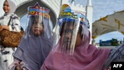 Дети в защитных масках в Индонезии, иллюстрационное фото