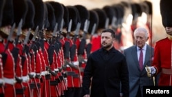 Ukrainian President Volodymyr Zelenskyy and Britain's King Charles inspect a guard of honor at Windsor Castle in Britain on October 24, 2025.