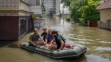 Volunteers evacuate residents from a flooded area after the Nova Kakhovka dam breached, in Kherson on June 7.