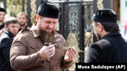 Рамзан Кадыров смотрит на кинжал шейха Мансура, подаренный ему во время церемонии открытия новой мечети в Чечне