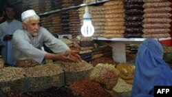 A woman buys dry fruit during the month of Ramadan as Eid al-Fitr approaches in Herat.