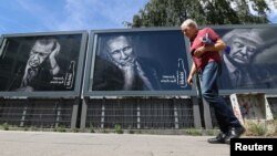 Прохожий в Гамбурге идет мимо рекламы прохладительных напитков с портретами президента Турции Эрдогана, президента России Владимира Путина и президента США Дональда Трампа. 6 июля 2017 года. 