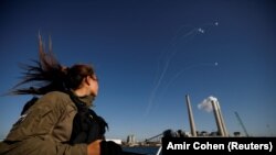 Vojnikinja Izraela gleda na Čeličnu kupolu, izraelski proturaketni sistem zaštite kojim presretaju rakete koje stižu iz Gaze