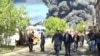Російські посадовці на тлі палаючого НПЗ у Туапсе після українського удару 28 квітня 2026 року