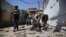 Afghan security officials inspect the scene of a bomb blast near a voter-registration center in Jalalabad on April 29.