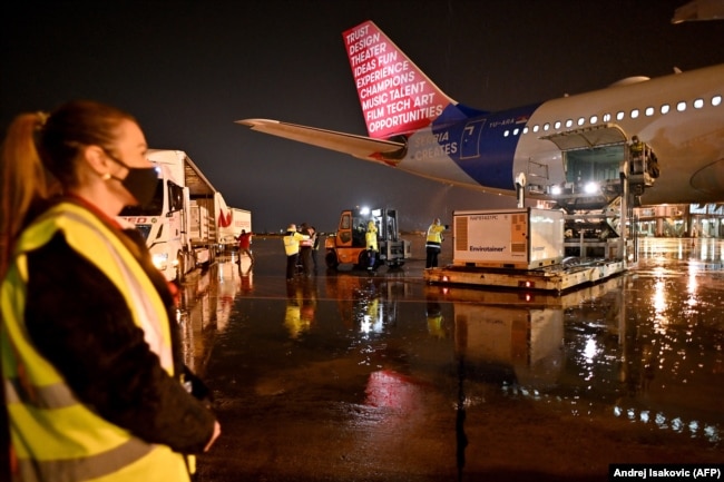 Workers unload containers holding 500,000 doses of China's Sinopharm vaccine from a special Air Serbia flight at Belgrade's airport on February 10.