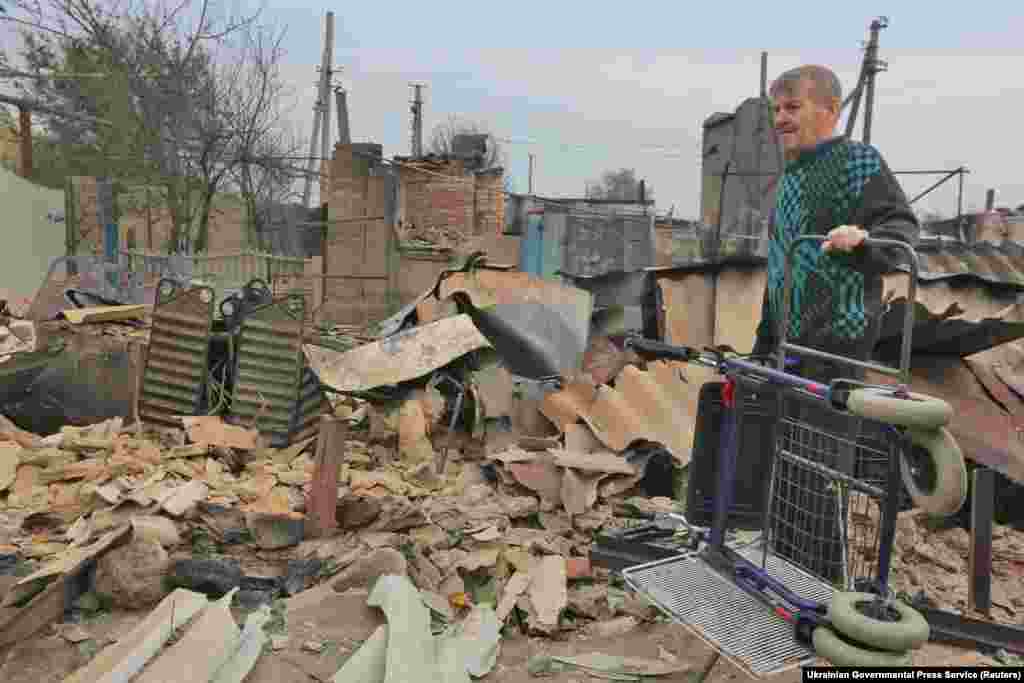 A local resident stands next to a destroyed building following a forest fire in the village of Syrotyne in Ukraine&#39;s eastern Luhansk region. (Ukrainian Governmental Press Service via Reuters/Sergii Kharchenko)