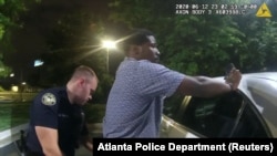 Поранешниот службеник на полицијата во Атланта, Гарет Ролф, го пребарува 27-годишниот Рејшард Брукс