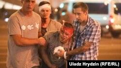 Сторонники оппозиции помогают раненому коллеге после подавления спецназовцами акций протеста. Минск, 10 августа 2020 года. 