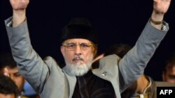 Tahir-ul-Qadri waves to supporters during an anti-government protest in front of the Parliament in Islamabad on August 27, 2014.