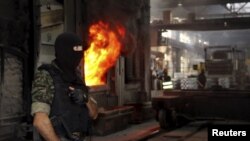 A member of Uzbek national security service, the SNB, stands guard while seized drugs are burned near Tashkent on June 25.