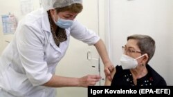 Женщина получает вакцину против коронавируса в одном из ЦСМ Бишкека. 