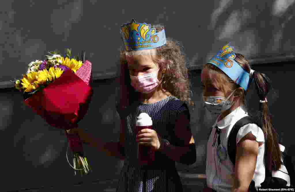 Romanian preschool students wearing blue printed toy crowns rush for their classes at the Leonardo da Vinci secondary school in Bucharest as schools open across Romania on September 13.