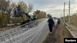 Ukrainian personnel install anti-drone nets over a road near the Dobropillya, northeast of Pokrovsk.