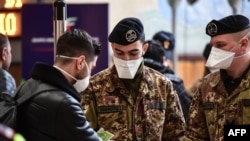 Italian soldiers in Milan, Italy check train passengers on March 9.