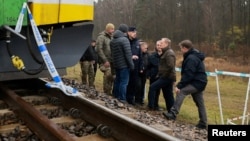 Premierul polonez Tusk (al doilea din dreapta) vizitează locul exploziei de pe linia ferată Varșovia-Lublin, în localitatea Mika, la 17 noiembrie 2025. 