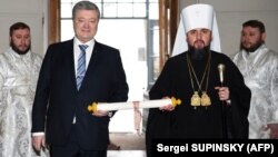 Ուկրաինայի նախագահ Պետրո Պորոշենկոն և Ուկրաինական եկեղեցու առաջնորդ Եպիֆանիոսը ձեռքերում պահել են Կոստանդնուպոլսի Տիեզերական պատրիարքի ստորագրած «տոմոսը», Կիև, 7-ը հունվարի, 2019թ․