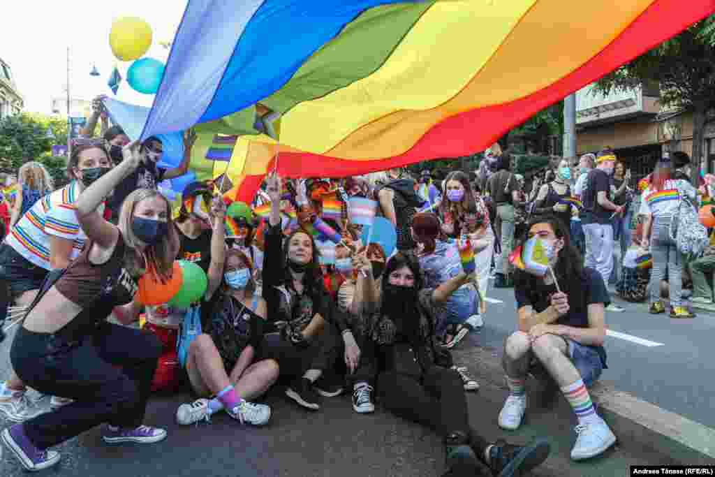 Un grup de tineri pozează sub steagul curcubeu, simbolul LGBT, în timpul Bucharest Pride.&nbsp;