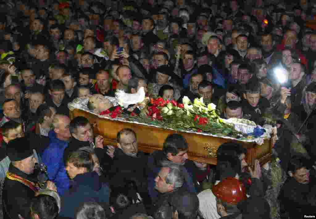 Mourners carry the coffin of an antigovernment protester in Kyiv on February 21.