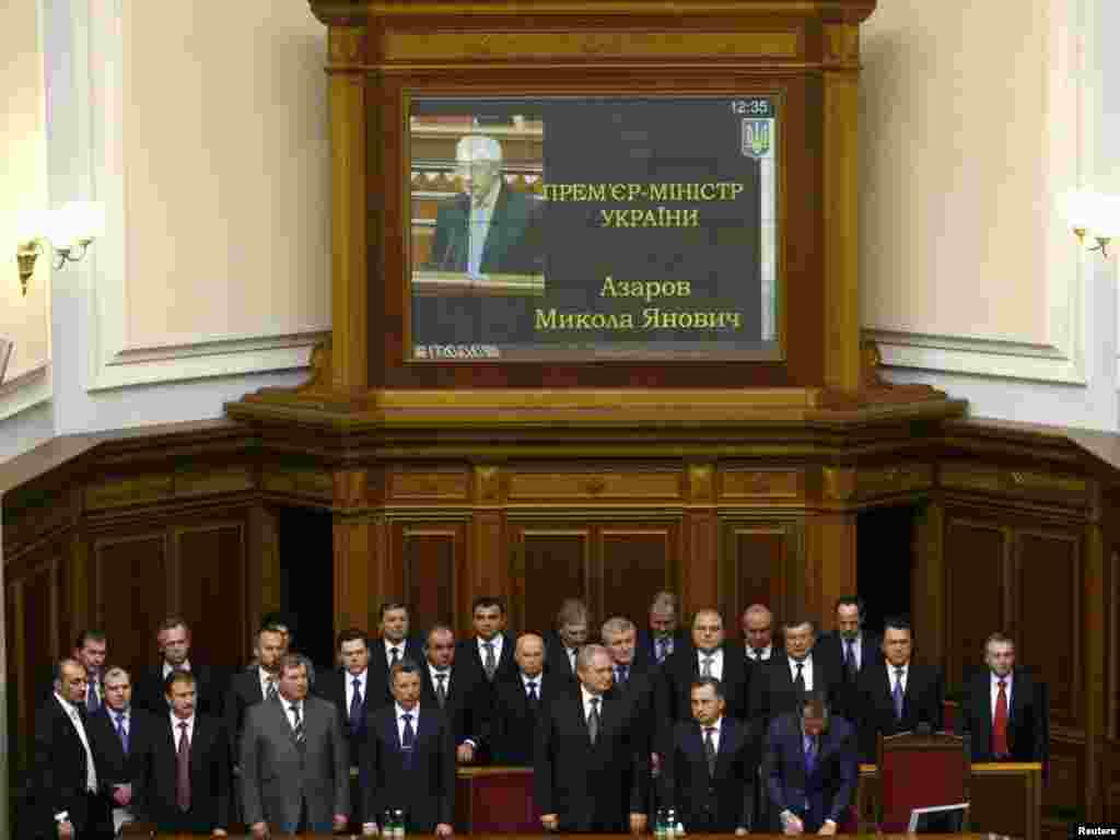 Члени нового Кабінету Міністрів стоїть під час складання присяги Прем'єр-міністром України Миколою Азаровим 11 березня