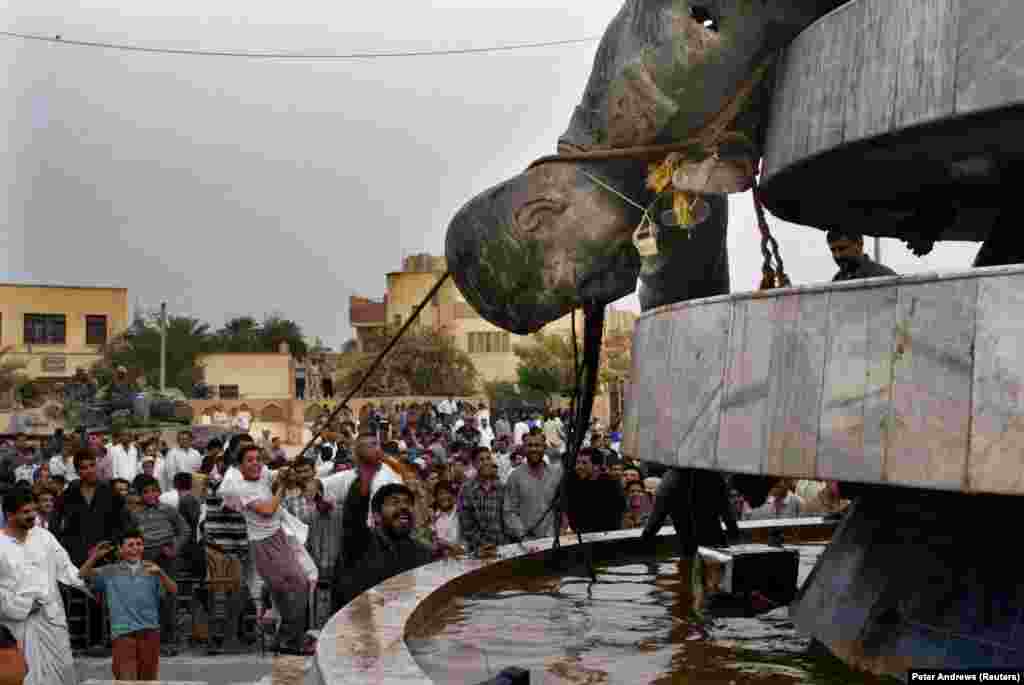 Iraqis tug at a toppled statue of Iraqi dictator Saddam Hussein after the U.S. invasion of the country in 2003. &nbsp;