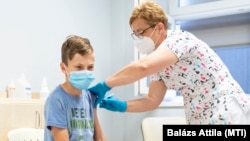 Vass Klára főorvos beolt egy 12 éves fiút a Pfizer-BioNTech koronavírus elleni oltóanyag, a Comirnaty-vakcinával a nyíregyházi Jósa András Oktatókórházban kialakított oltóponton, 2021. június 23-án