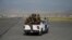 Taliban fighters ride on a vehicle on the runway of the airport in Kabul on August 31. 