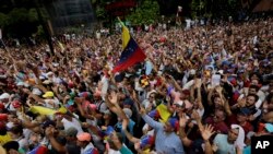 Anti-government protesters hold their hands up during the symbolic swearing-in of Juan Guaido. January 23.