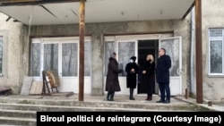 Reprezentanți ai guvernului, la intrarea în clădirea liceului „Evrika” din orașul Râbnița, preluată forțat de autoritățile separatiste în 2004. Vizita a avut loc în decembrie 2021.