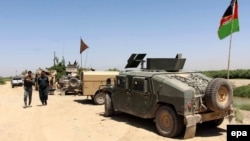 Members of the Afghan security services take position during an operation in an area retaken from the Taliban, in the Ainak area of Nawa district, Helmand Province, on April 26.