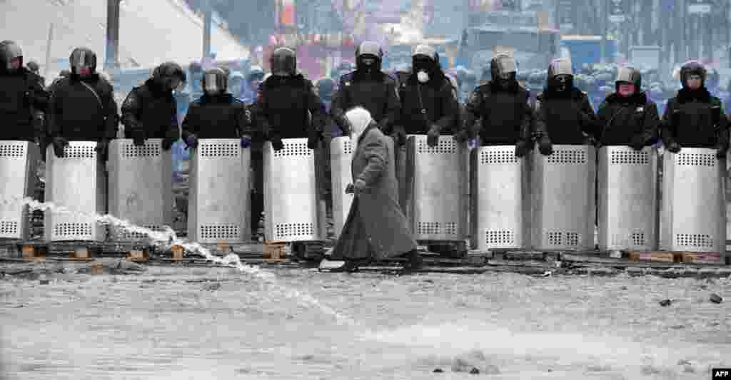 Жанчына праходзіць каля шэрагу спэцназаўцаў на вуліцы Грушэўскага ў цэнтры Кіева.