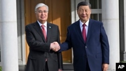 Chinese leader Xi Jinping (right) is greeted by Kazakh President Qasym-Zhomart Toqaev in Astana on July 2 for a state visit ahead of a two-summit for the Shanghai Cooperation Organization.