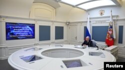 პუტინი მარტო იჯდა მრგვალ თეთრ მაგიდასთან და უყურებდა დიდ ეკრანებს.