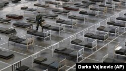 Сербський військовий ходить поміж ліжок в облаштованій для можливих хворих на COVID-19 будівлі Белградської ярмарки, 24 березня 2020 року