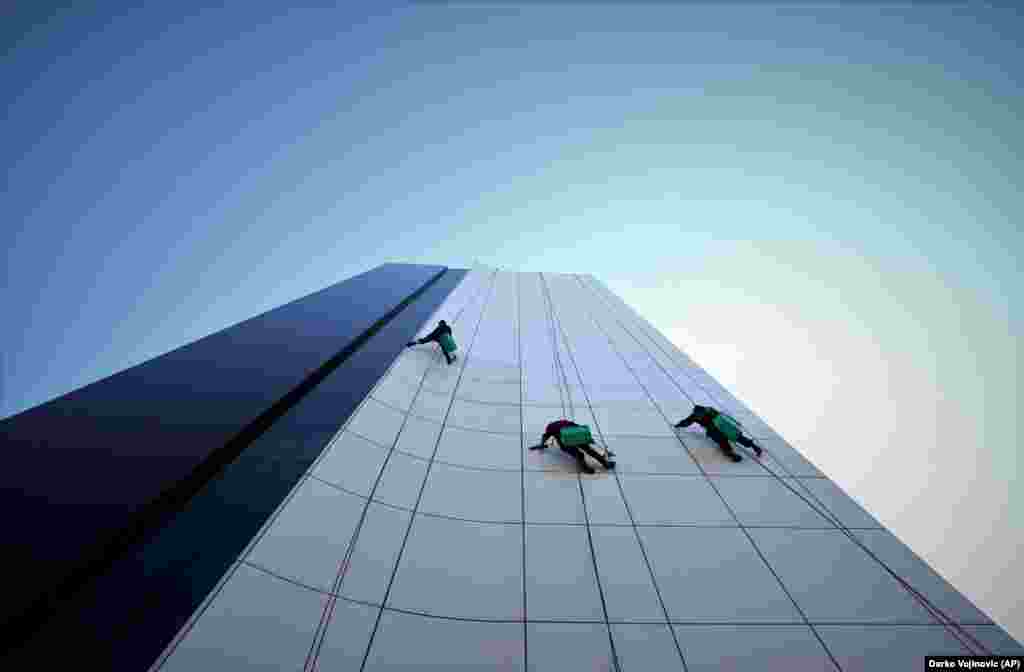 Workers clean the windows and the facade of an office building in Baku.